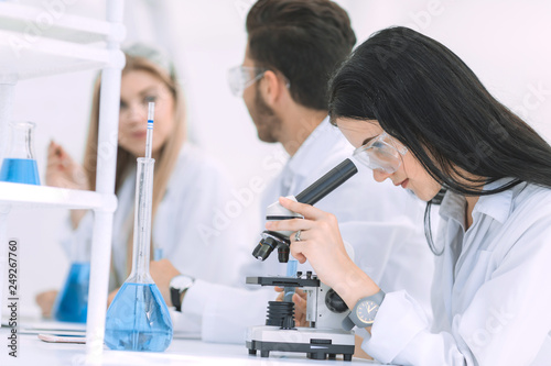 female scientist uses a microscope in the laboratory