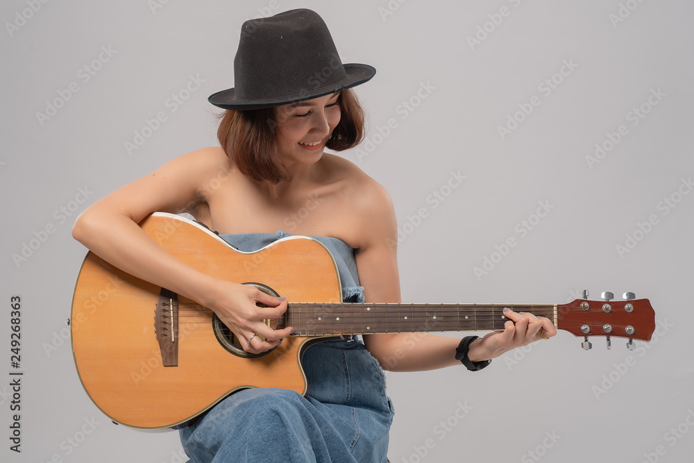 Stockfoto med beskrivningen guitar, woman, playing, music, girl, young,  isolated, acoustic, people, play, white, person, sitting, adult, caucasian,  one, female, casual, portrait, beautiful, instrument, beauty, background,  guitar | Adobe Stock