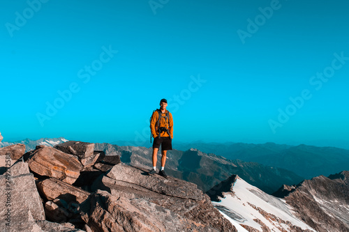 Man posing on a rock at the Kesskogel summit in Hohe Tauern national park photo