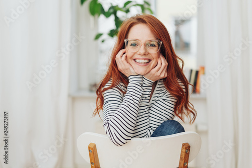 Happy friendly young woman with hands to her face