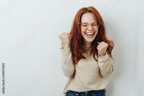 Exuberant young woman cheering and punching air