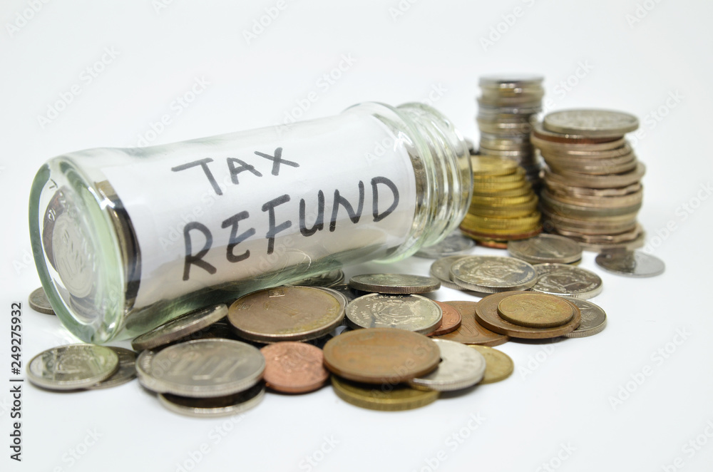 Tax refund lable in a glass jar with coins spilling out Tax refund lable in a glass jar with coins spilling out
