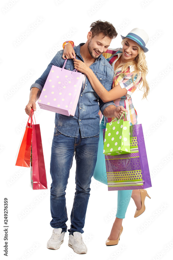 Attractive young couple with shopping bags on white background