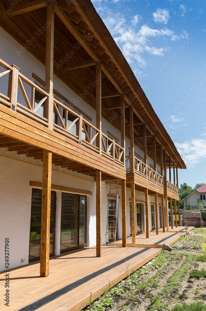 Modern wooden alpine Style Architecture with Balcony and varnished wooden Slats, shingles and Timbers
