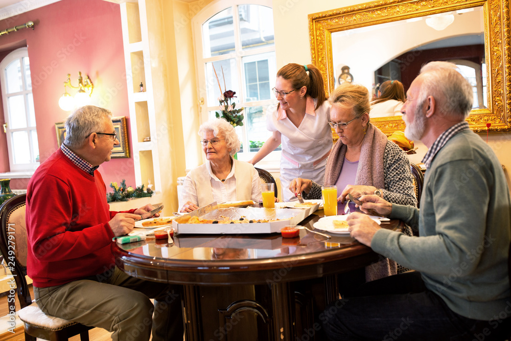 Nurse serving retirement home occupants during dinner time Nurse serving retirement home occupants during dinner time