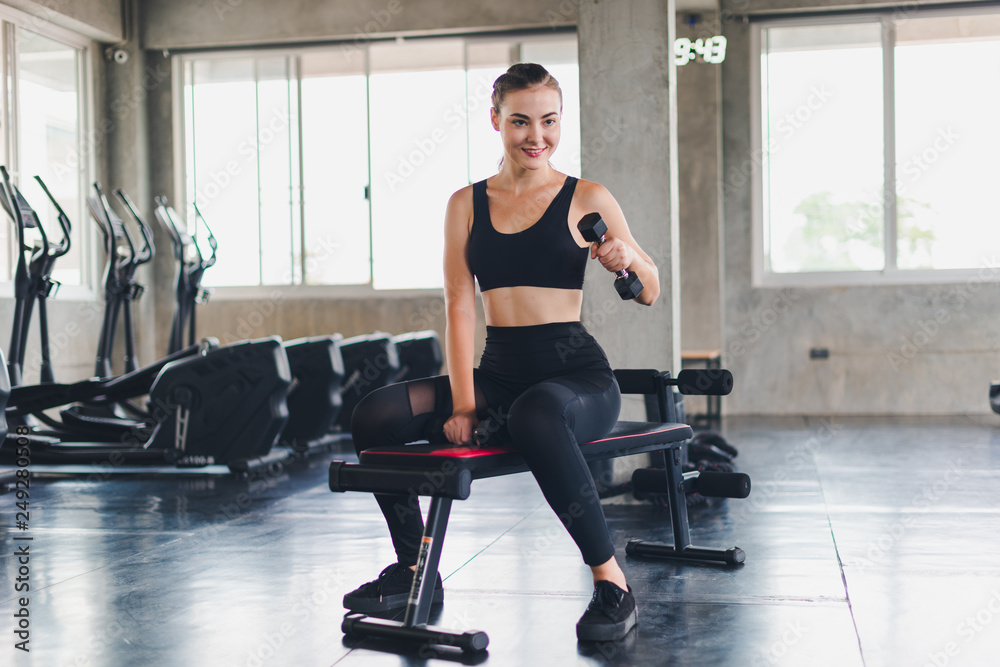 Beautiful girl caucasian is exercising with lifting dumbbell in the gym. Female athletes play a healthy training session. Beautiful girl caucasian is exercising with lifting dumbbell in the gym. Female athletes play a healthy training session.