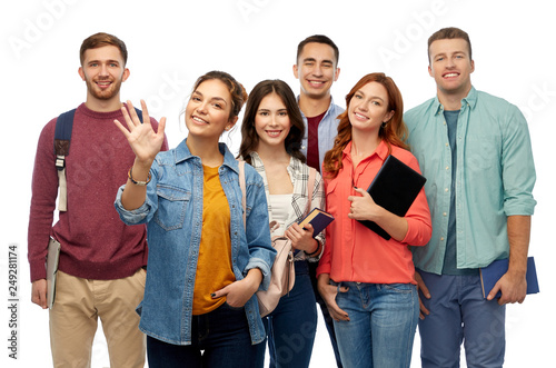 education, high school and people concept - group of smiling students with books waving hands over white background