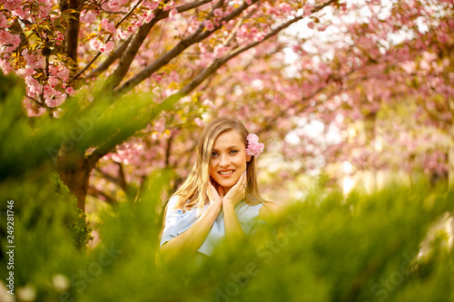 Outdoor fashion photo of young beautiful lady surrounded spring leaves