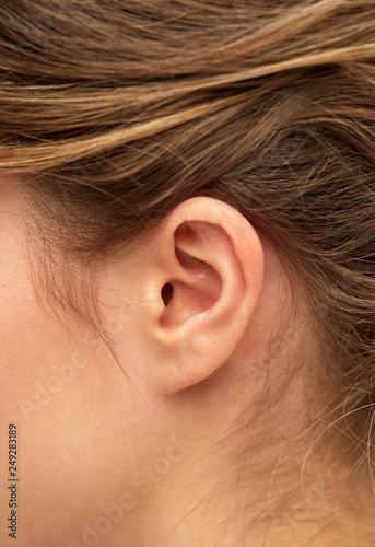 health, people and beauty concept - close up of young woman pointing finger to her ear