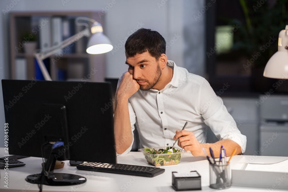 business, overwork, deadline and people concept - stressed businessman with computer eating at night office