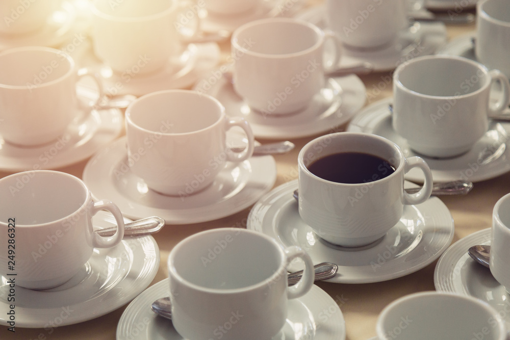 Coffee mug that are filled with coffee and that mugs among empty coffee cups. preparing for break time. Coffee mug that are filled with coffee and that mugs among empty coffee cups. preparing for break time.