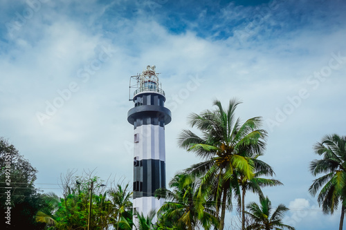 Lighthouse among tropical palm trees in Kerala. India