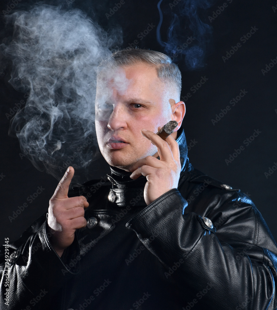 Portrait of handsome man with a cigar in leather jacket Portrait of handsome man with a cigar in leather jacket