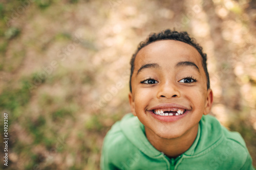 Close up of smiling boy standing in forest photo