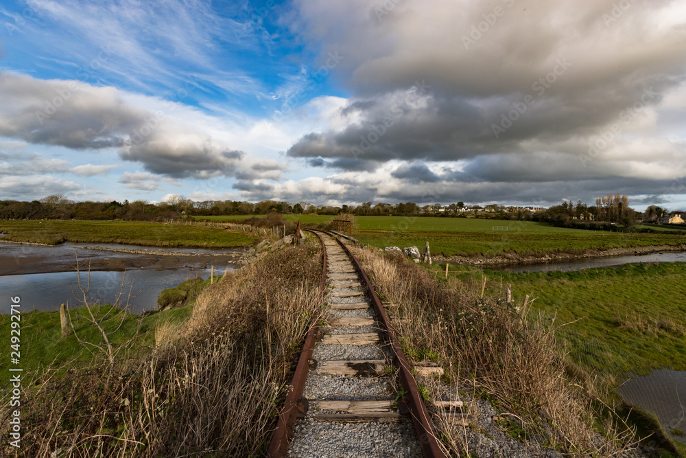 landscape of old unused and abandonned rusty train tracks in rural Ireland