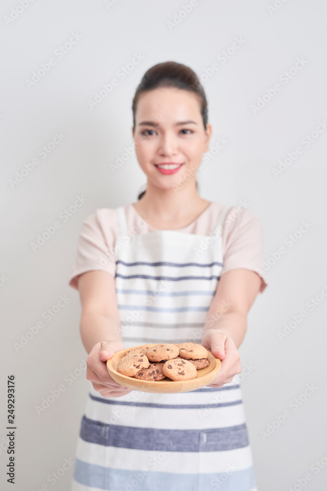Young woman holding a plate of homemade chocolate cookies Young woman holding a plate of homemade chocolate cookies