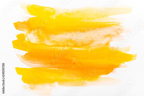 top view of yellow watercolor brushstrokes on white paper