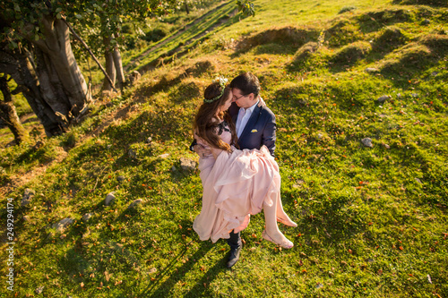 Beautiful wedding couple posing on green hills