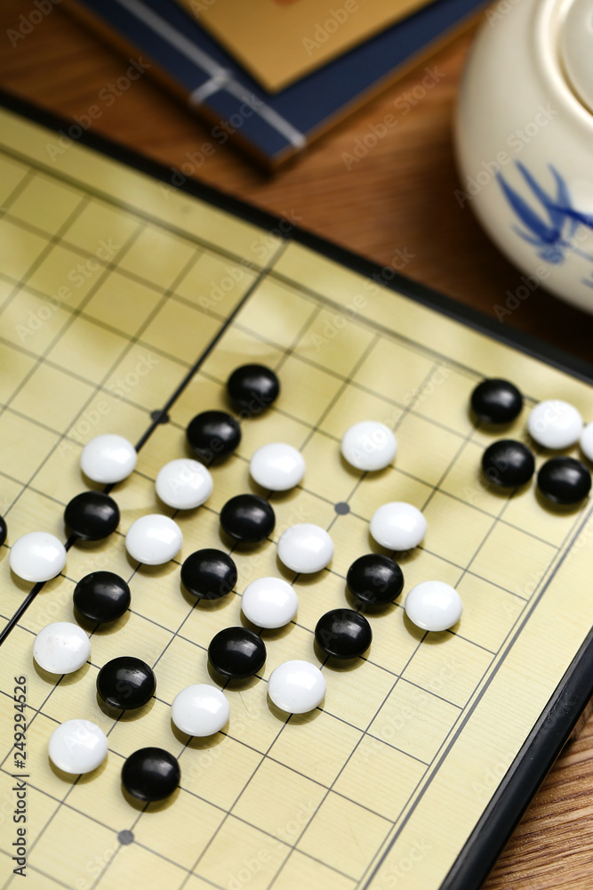 Chinese go game board, close up view of playing black and white stone pieces Chinese go game board, close up view of playing black and white stone pieces