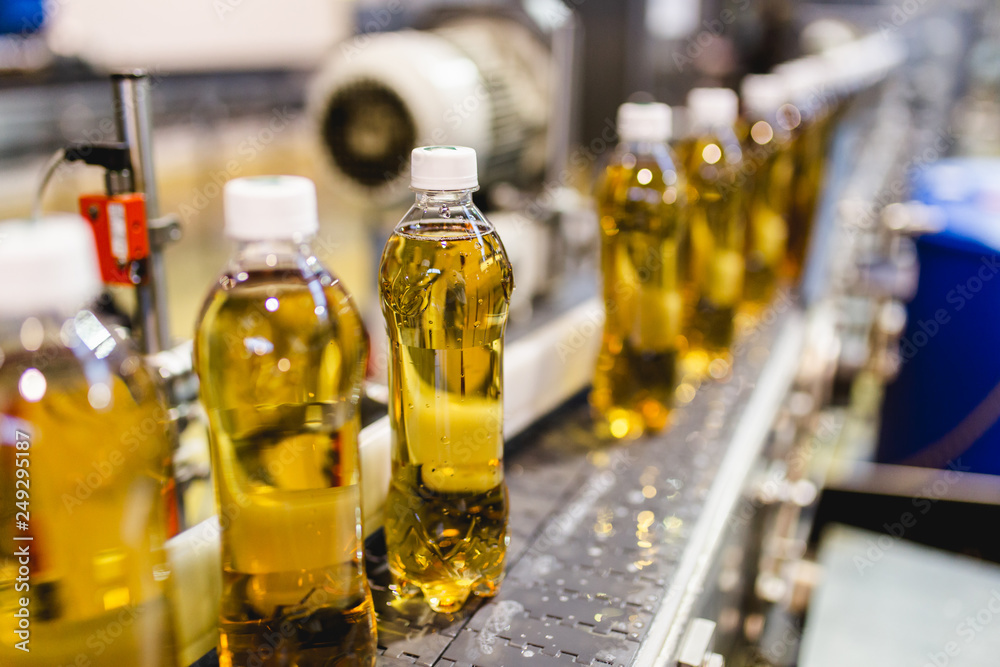 Bottling factory - Apple juice bottling line for processing and bottling juice into bottles. Selective focus. Bottling factory - Apple juice bottling line for processing and bottling juice into bottles. Selective focus.