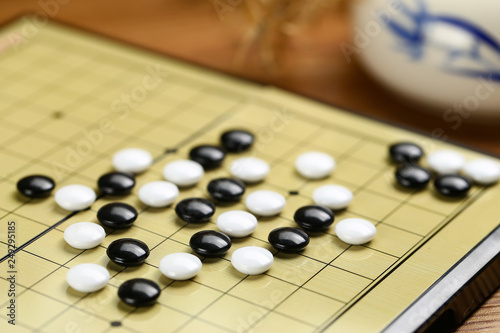 Chinese go game board  close up view of playing black and white stone pieces