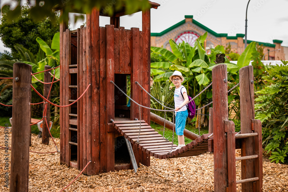 Blonde boy in the straw hat and big glasses and girl in white and blue dress in the entertainment park