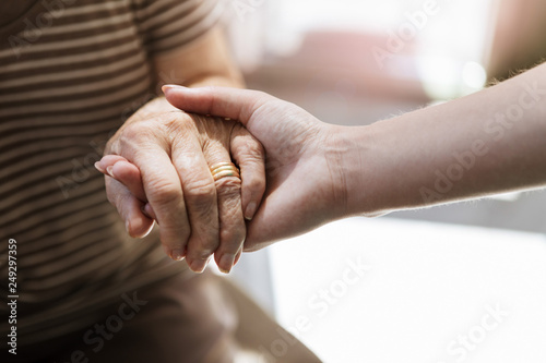 Close up of nurse holding hand of senior woman photo