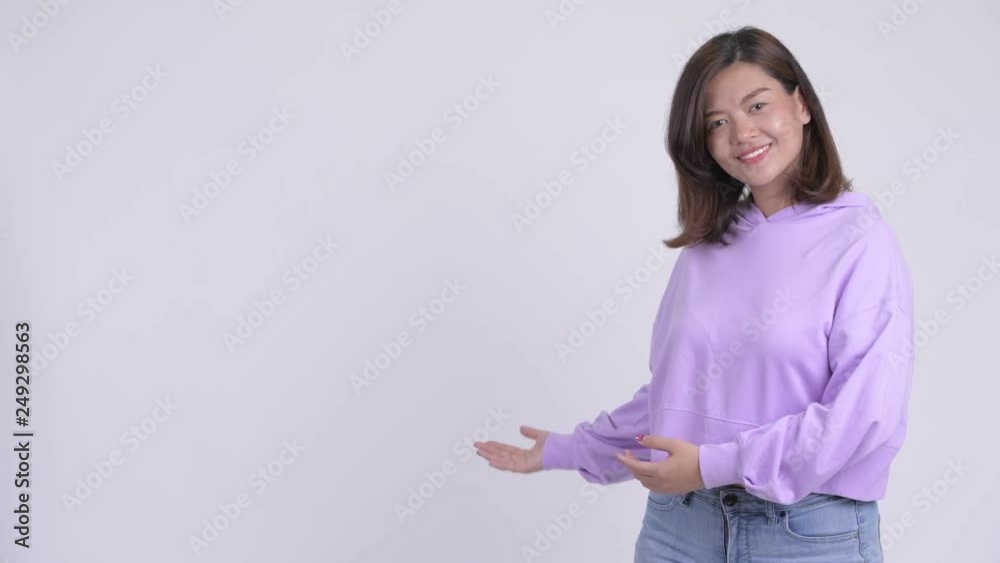 Young happy Asian woman showing something Young happy Asian woman showing something