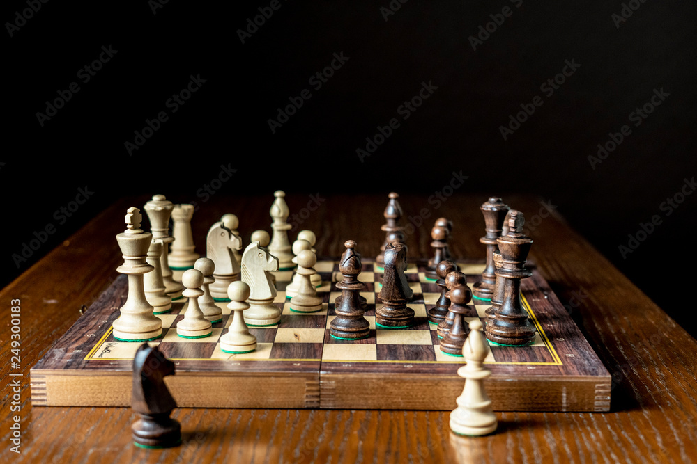 chessboard and figures placed on it and near it chessboard and figures placed on it and near it