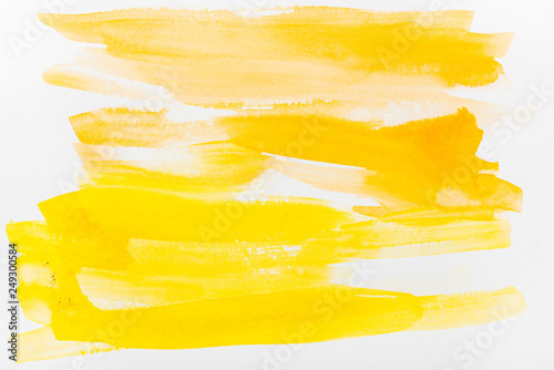 top view of yellow watercolor brushstrokes on white background