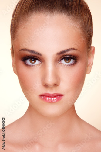 Close-up portrait of young beautiful tanned girl with stylish make-up
