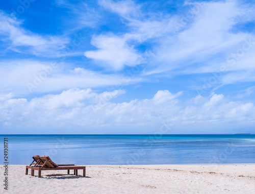 Chairs on the amazing beautiful sandy beach near the ocean with blue sky. Concept of summer leisure calm vacation for a tourism idea. Empty copy space, inspiration of tropical landscape © RomixImage