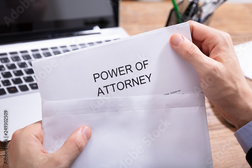 Person Removing Power Of Attorney Document From Envelope