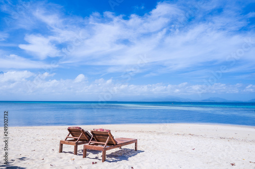 Chairs on the amazing beautiful sandy beach near the ocean with blue sky. Concept of summer leisure calm vacation for a tourism idea. Empty copy space, inspiration of tropical landscape