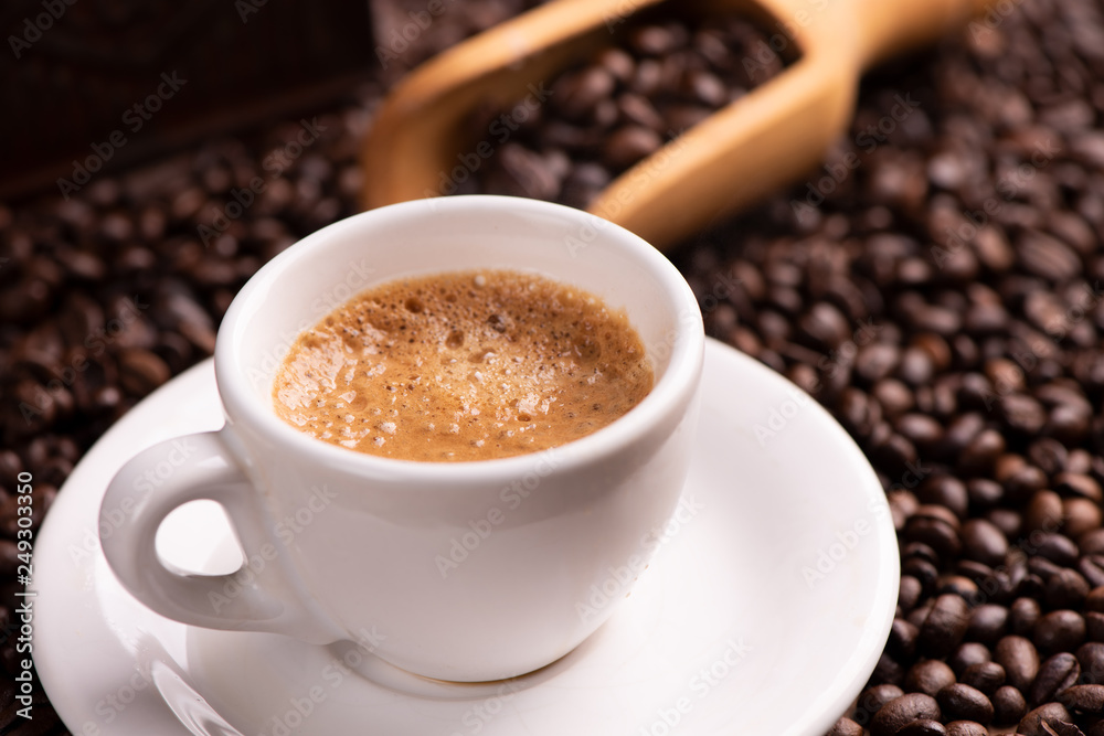 Coffee cup over dark roasted coffee beans Coffee cup over dark roasted coffee beans