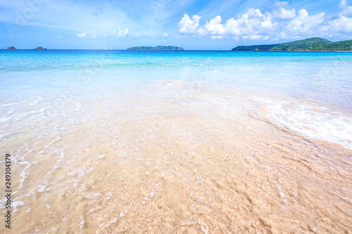 Beautiful amazing gold colored sandy beach with soft waves isolated with sunny blue sky. Concept of tropical calm tourism idea  copy space  close up