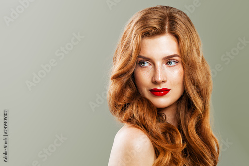 Young beautiful red haired woman. Redhead girl with ginger curly hairstyle on green background