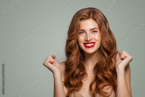 Billede på lærred Red head girl with long and shiny curly hair