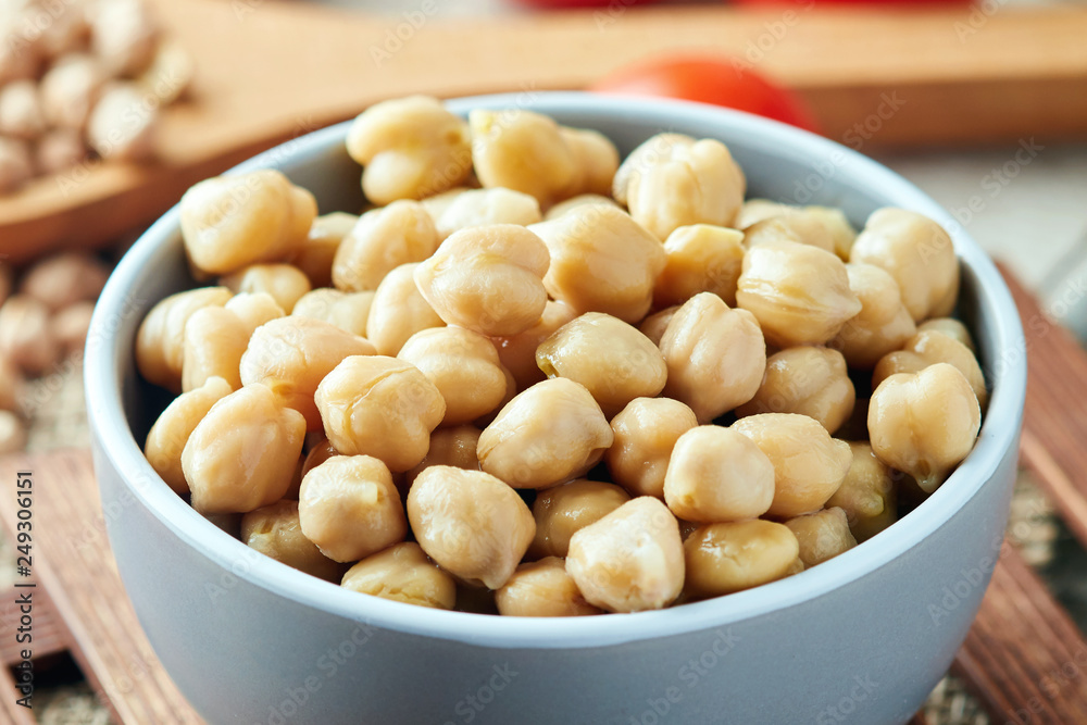 Cooked chickpeas (Cicer arietinum) in bowl on wooden background Cooked chickpeas (Cicer arietinum) in bowl on wooden background