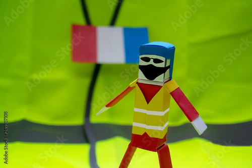 The paper figure depicts a protester in France. Yellow vests.