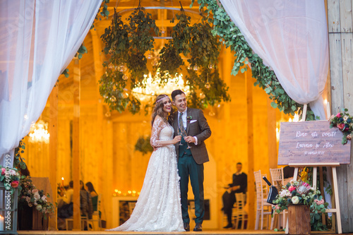Beautiful fashion wedding couple posing in front of barn wedding venue