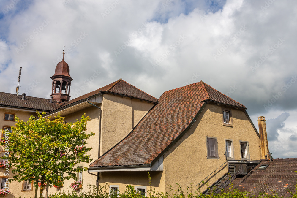 Old houses with tiled roofs and turrets against a cloudy sky in Bern, Switzerland Old houses with tiled roofs and turrets against a cloudy sky in Bern, Switzerland
