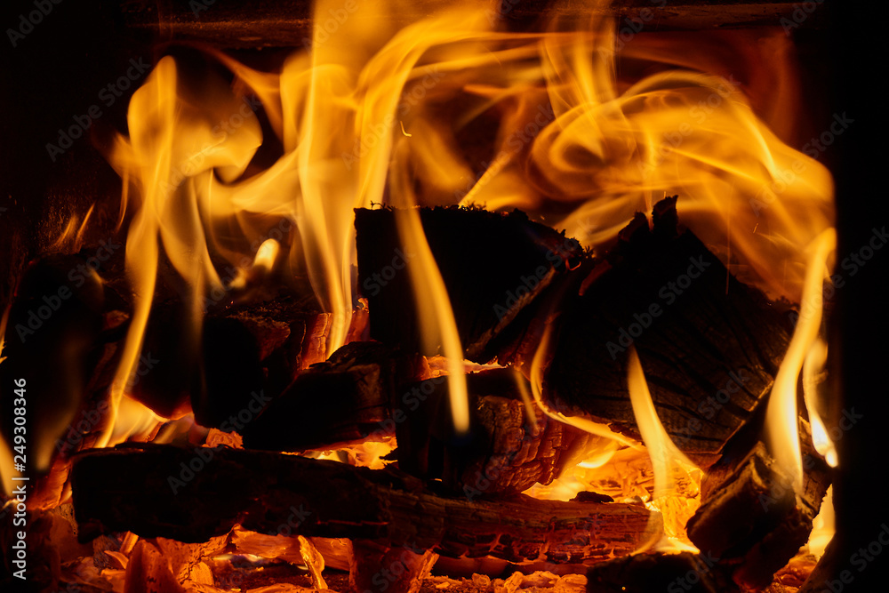 Orange flame from burning oak wood in a Russian stove. Wonderful fire. Red burning coals and black charred wood. Fire like texture for design. Orange flame from burning oak wood in a Russian stove. Wonderful fire. Red burning coals and black charred wood. Fire like texture for design.