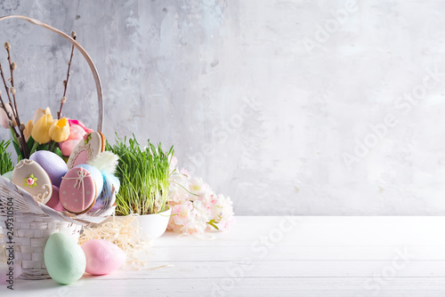 Easter greeting card with glazed cookies and colorful easter eggs in basket . With copy space photo