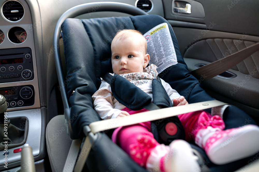 Seatbelt securing the position and stability of a baby car seat with baby in it