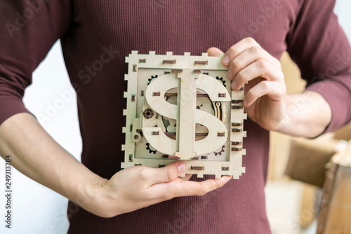 young man hold concept of mini bank safe with dollar icon b