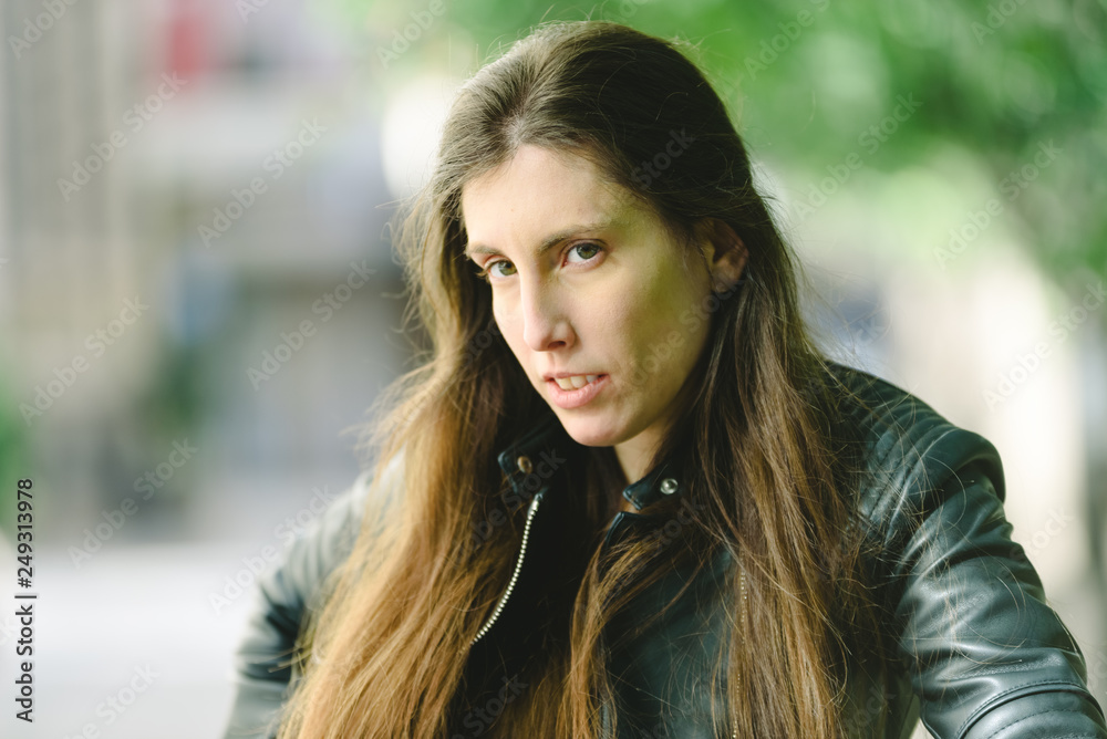 Young model woman with long straight hair wearing leather jacket posing carefree and casual on the street. Young model woman with long straight hair wearing leather jacket posing carefree and casual on the street.