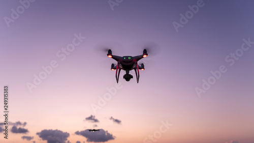 Drone quadcopters with high resolution digital camera Drone flying in sunset or sunrise beautiful sky