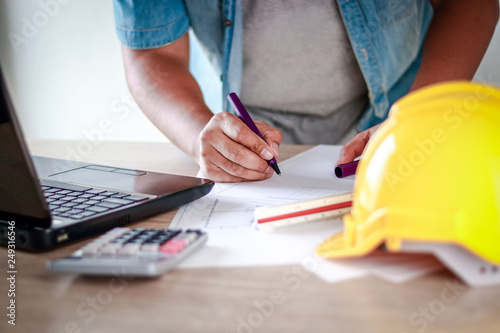 Asian men working construction Hold pen to write information on paper.