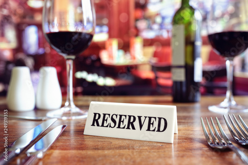 Fotografi Reserved sign on restaurant table with bar background